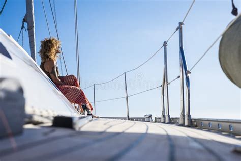 Jeune femme sur un voilier profitant du soleil