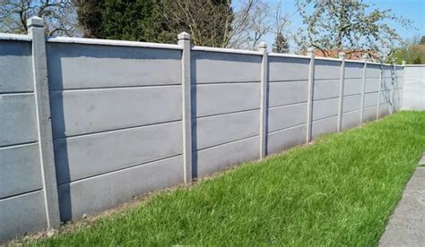 Poteaux en béton dans un jardin avec une clôture moderne