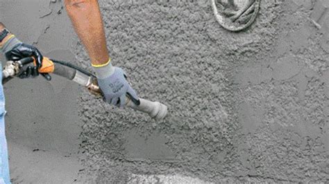 Application d'un gobetis sur un mur en béton