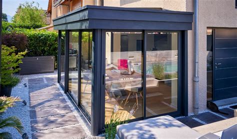 Une belle véranda en aluminium moderne adossée à une maison