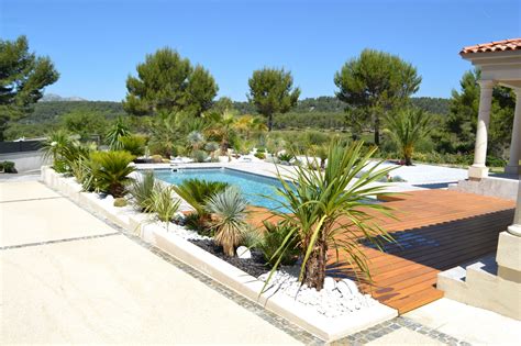 Aménagement paysager avec plantes luxuriantes autour d'une piscine