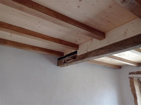 Illustration de flasques métalliques fixés sur une poutre en bois