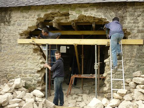 Ouvrier créant une ouverture dans un mur en parpaing