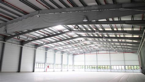 Intérieur d'un bâtiment industriel avec charpente métallique apparente