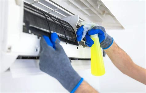 Technicien nettoyant les filtres d'une unité intérieure de climatisation