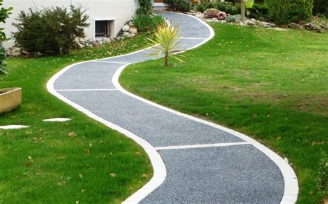 Allée en béton drainant bordée de végétation dans un jardin urbain
