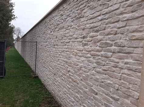 Mur en parpaing revêtu de plaquettes de parement imitation pierre