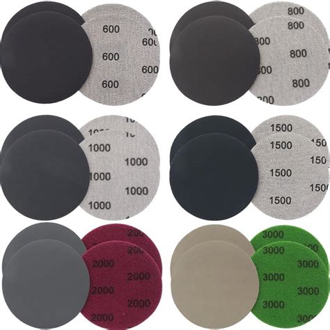 Technicien utilisant du papier abrasif Kovax pour le ponçage à sec d'une carrosserie de voiture