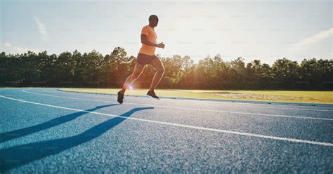 Un athlète courant sur un bitume ensoleillé