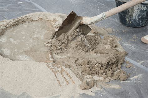 Artisan versant du mortier coloré dans un moule de carreau de ciment