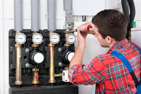 Plombier chauffagiste travaillant sur une chaudière