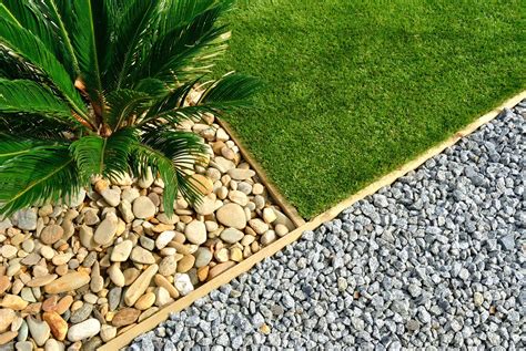 Cour de gravier avec des bordures en bois et des plantes environnantes