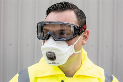 Personne portant un masque de protection et des lunettes de sécurité pendant le ponçage