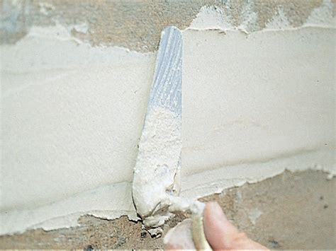 Application de mortier de réparation sur une pierre de taille