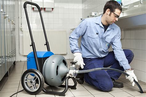 Plombier effectuant un débouchage de canalisation