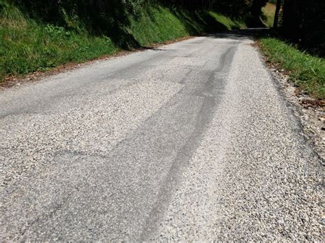Photographie d'une équipe réalisant des travaux de gravillonnage sur une route