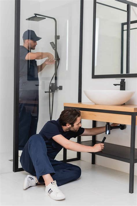 Artisan plombier travaillant dans une salle de bain moderne