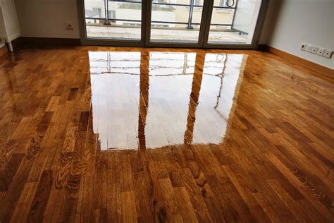 Vue rapprochée d'un parquet en cours de vitrification, montrant l'application uniforme du produit