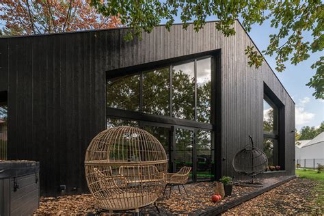 Maisonnette scandinave avec bardage bois brûlé et toiture végétalisée