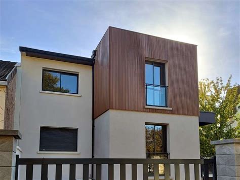 Façade de maison urbaine avec bardage bois brûlé et touches de couleur