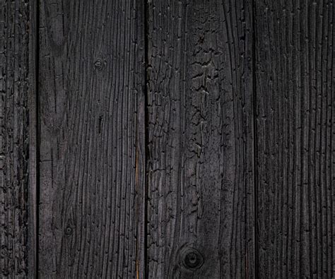 Détail d'une façade en bois brûlé montrant la texture