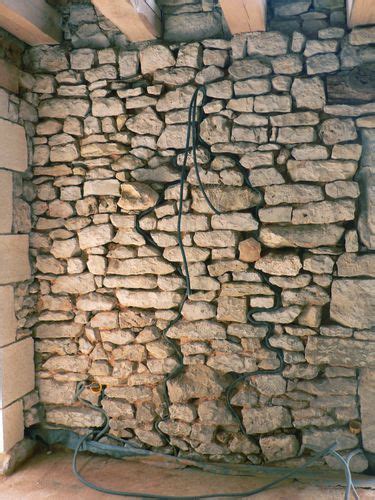 Murs en pierre anciens avec des gaines apparentes