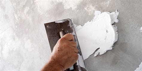 Ouvrier appliquant de l'enduit sur une plaque de plâtre