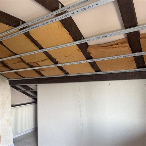 Rouleau d'isolant posé sur une ossature de faux plafond