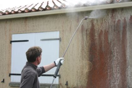 Application de produit nettoyant sur une façade avec un pulvérisateur