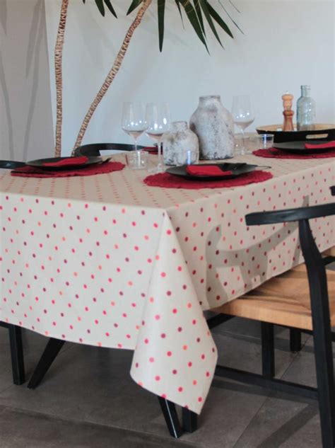 Gros plan sur une texture de nappe enduite à pois, montrant l'effet déperlant d'une goutte d'eau