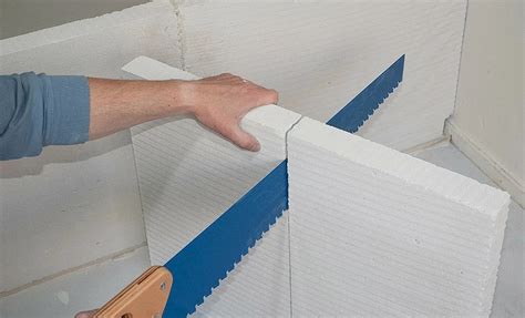 Application de colle en pâte sur un bloc de béton cellulaire