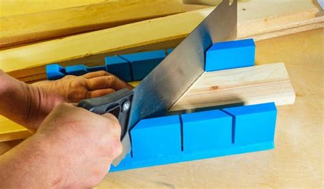 Utilisation d'une boîte à onglet pour couper une plinthe en aluminium à 45 degrés