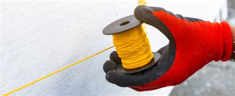 Utilisation d'un cordeau à tracer pour marquer une ligne horizontale sur un mur