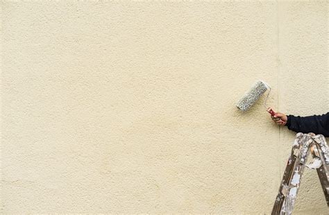 Application de peinture au rouleau sur un mur extérieur