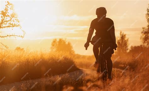 Cycliste sur un sentier de gravier bordé d'arbres