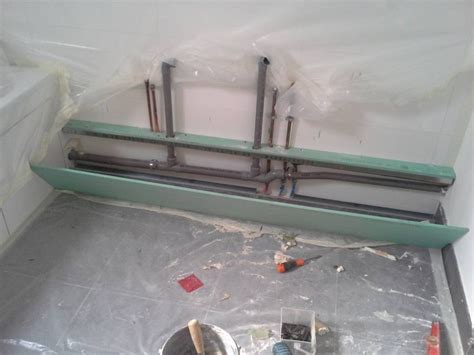 Exemple de coffrage en bois dissimulant des tuyaux de plomberie derrière un meuble de salle de bain