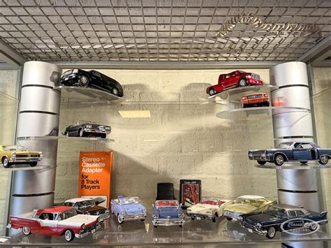 Étagère murale en forme d'aileron de voiture avec des modèles réduits de voitures