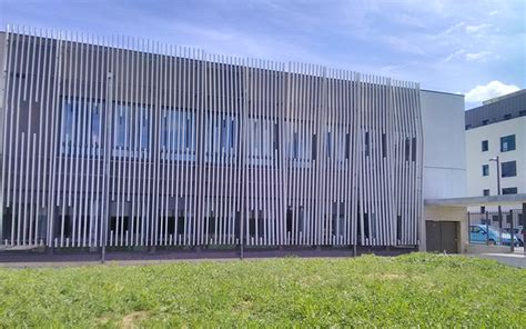 Façade en bois avec lames horizontales de tailles variées et hublots