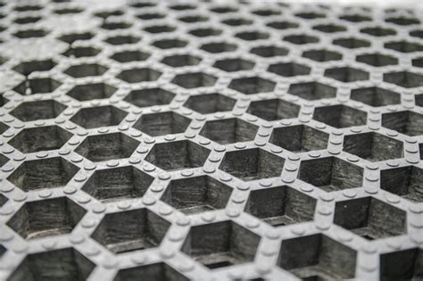 Schéma technique d'une dalle stabilisatrice de gravier montrant les alvéoles et le géotextile