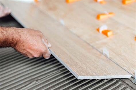 Artisan carreleur travaillant sur un parquet