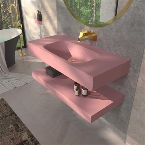 Salle de bain avec un mur violet profond, une vasque rose pâle et des accents dorés