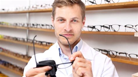 Une personne inspectant attentivement ses lunettes pour détecter des rayures.