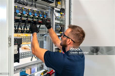 Électricien travaillant sur un panneau de contrôle de portail