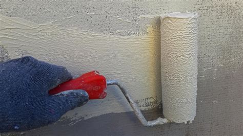 Application de vernis au rouleau sur un mur