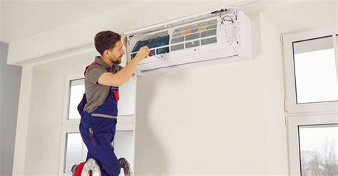 Technicien installant une unité intérieure de climatisation