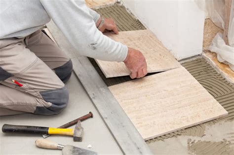 Artisan carreleur posant du carrelage