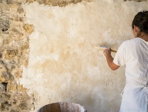 Application d'un badigeon à la chaux sur un mur intérieur