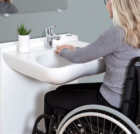 Personne en fauteuil roulant utilisant un lavabo réglable en hauteur