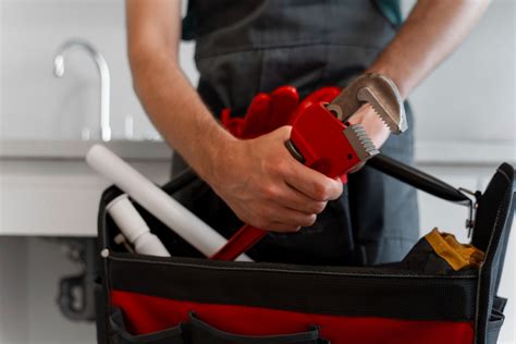 Un plombier souriant tenant des outils