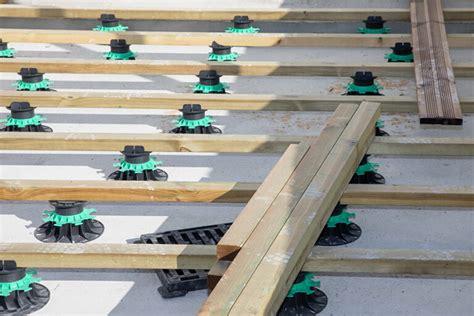 Diagramme illustrant la pose de plots amortisseurs sous une structure en bois